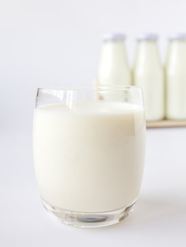 Bottle of milk and glass of milk on a white background