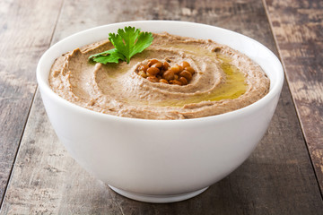 Lentil hummus in bowl on wood