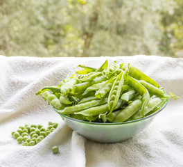 Green peas. pods in a glass bowl