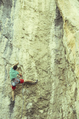 Rock climber ascending a challenging cliff. Extreme sport climbing. Freedom, risk, challenge, success.