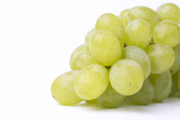Fresh green grapes with waterdrops on the white background.
