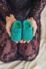 close up woman touching holding baby shoes