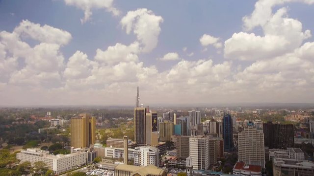 Nairobi skyline - wide angle establishing shot. Camera pan from blue sky to the city