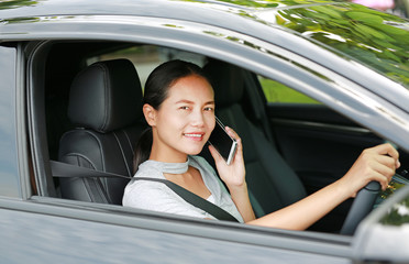 Brunette young woman talking on the phone while driving.