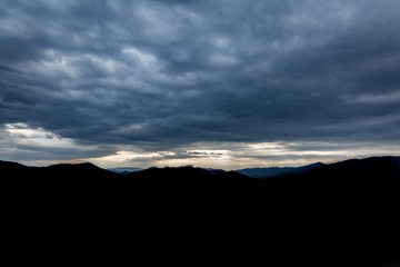 Obraz premium Dramatic Clouds at Sunset in the Mountains