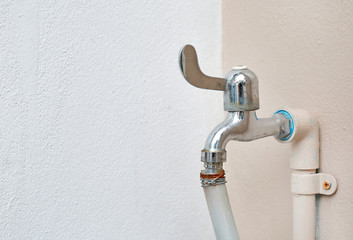 Water tap connector with rubber pipe at the wall.