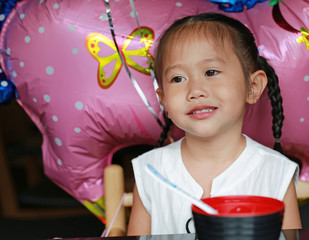 Happy little girl enjoys eating miso soup.