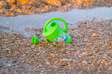 Children toy for watering flowers on the beach