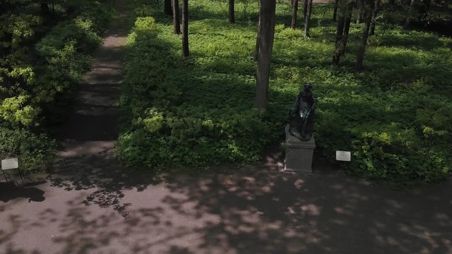 Bronze statues standing in the forest in the thicket among the trees of different gods male female statues of the Venus Zeus Cupid