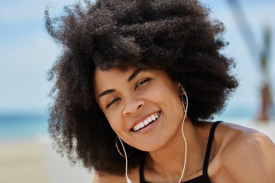 Happy afro american woman listening music on outside