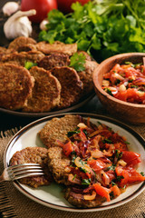 Eggplant fritters served with stewed tomatoes and onion, vegetarian food.