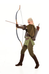 full length portrait of a blonde girl wearing green and brown medieval costume, holding a bow and arrow. isolated on white background.