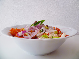 Delicious greek salad on a white ceramic plate