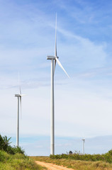 white wind turbines generating electricity in wind power station under blue sky background        