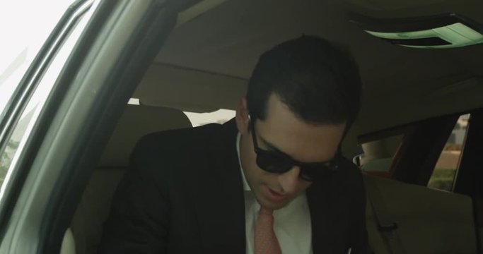 Close up, wealthy man gets out of limo in slow motion