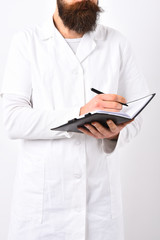 Medical doctor with stylish beard and moustache holding note pad.