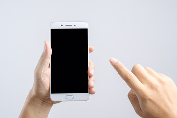 Hand holding new 6 inch smart phone with blank screen and  pointing index finger
