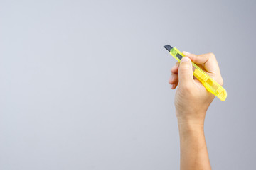 Hand holding office yellow paper cutter