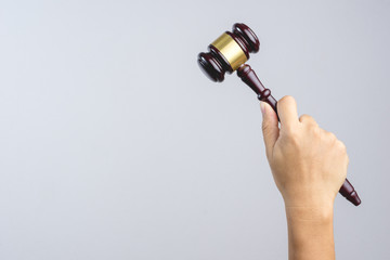 Hand holding wooden judge's gavel as a law or justice sign