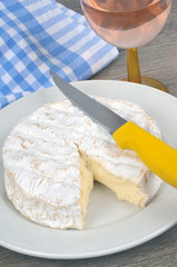 Camembert dans une assiette avec un verre de rosé 