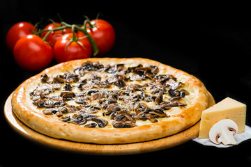 selective focus on classic appetizing Italian fresh cheese pizza with marinated mushrooms on wooden round board on dark background, near tomatoes and cheese