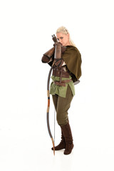 full length portrait of a blonde girl wearing green and brown medieval costume, holding a bow and...
