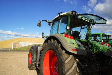 Traktor mit großem Maishaufen im Hintergrund