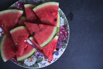 Sliced slices of watermelon on a dark background.