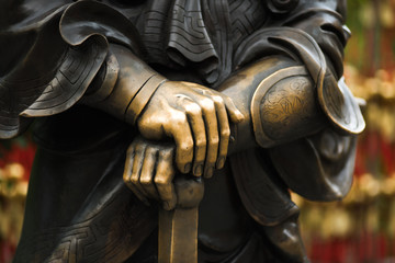Fototapeta na wymiar Close up hands and sword of Statue of Chinese General in wong tai sin