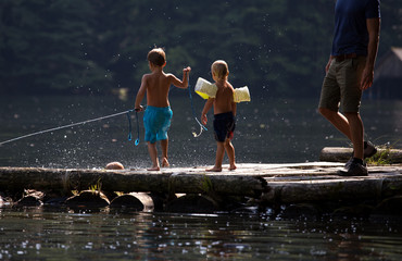 Boys playing on dock on lake
