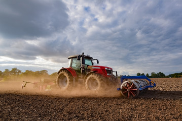 Ackerbau - roter Traktor bei der Herbsteinsaat