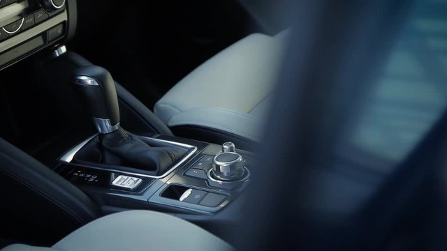 View of modern car interior with automatic transmission box, seats and steering wheel, panning effect.