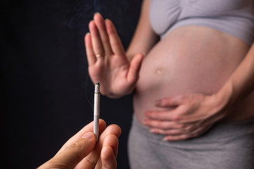 A pregnant woman with belly refuses passive Smoking. Concept of the rejection of bad habits