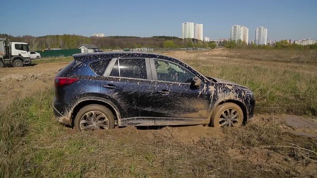 SUV car stuck in the mud trying to get out.