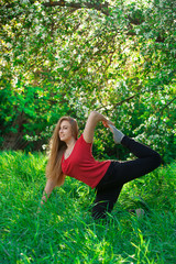 Naklejka na ściany i meble beautiful woman doing yoga outdoors On green grass