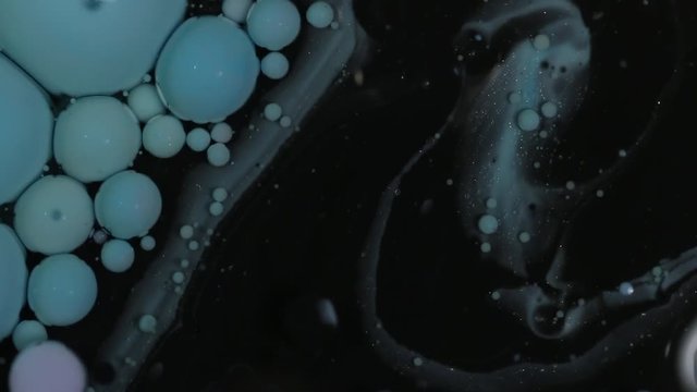 Dark dyes spin on water, macro close up