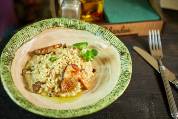 Risotto with chicken, peas and tomatoes on a wooden board, Italian