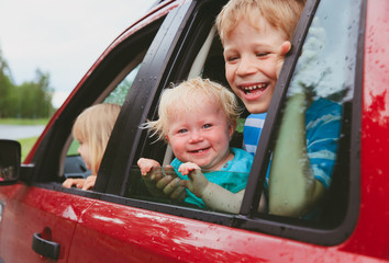 happy little boy and two girls travel by car
