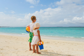 Naklejka premium little boy and girl go play on beach