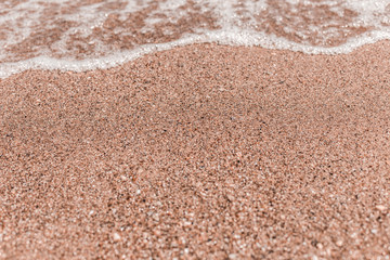 Fototapeta na wymiar Soft wave on sandy beach. Sea travel and holiday. Selective focus
