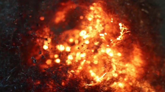Close up, fire erupts inside steel wool