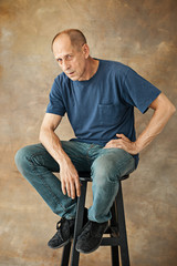 Worried mature man sitting at studio