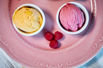 Selection of gourmet flavours of Italian ice cream in vibrant colors served in individual porcelain cups on an old rustic wooden table in an ice cream parlor, angle view jpg