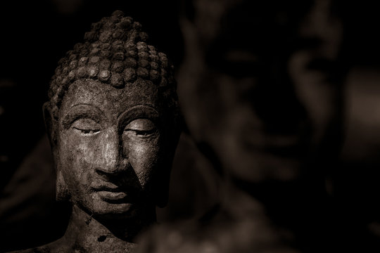 Head of Buddha statue in the dark, the dark side of Buddha, antique and ancient statue of buddha