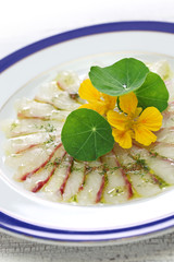 fish carpaccio, thinly sliced raw sea bream appetizer, italian dish