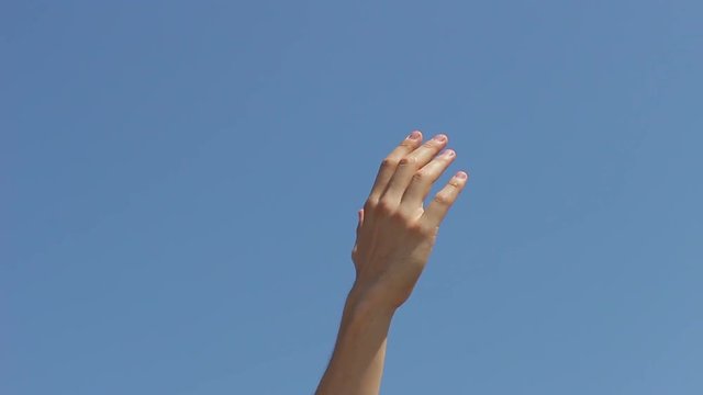 Hand against blue sky background