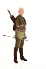 full length portrait of a blonde girl wearing green and brown medieval costume, holding a bow and...