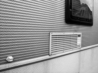 Struktur eines alten Wohnwagen mit spiegelndem Fenster für Camping und Vanlife beim Oldtimertreffen Golden Oldies in Wettenberg Krofdorf-Gleiberg bei Gießen in Hessen in Schwarzweiß