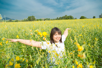 Fototapeta premium asian young chubby women is raising arms to the sky in yellow field at summer, Thailand
