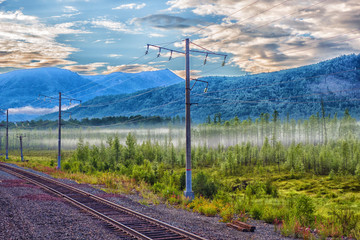 railway in the mountains, fog at dawn